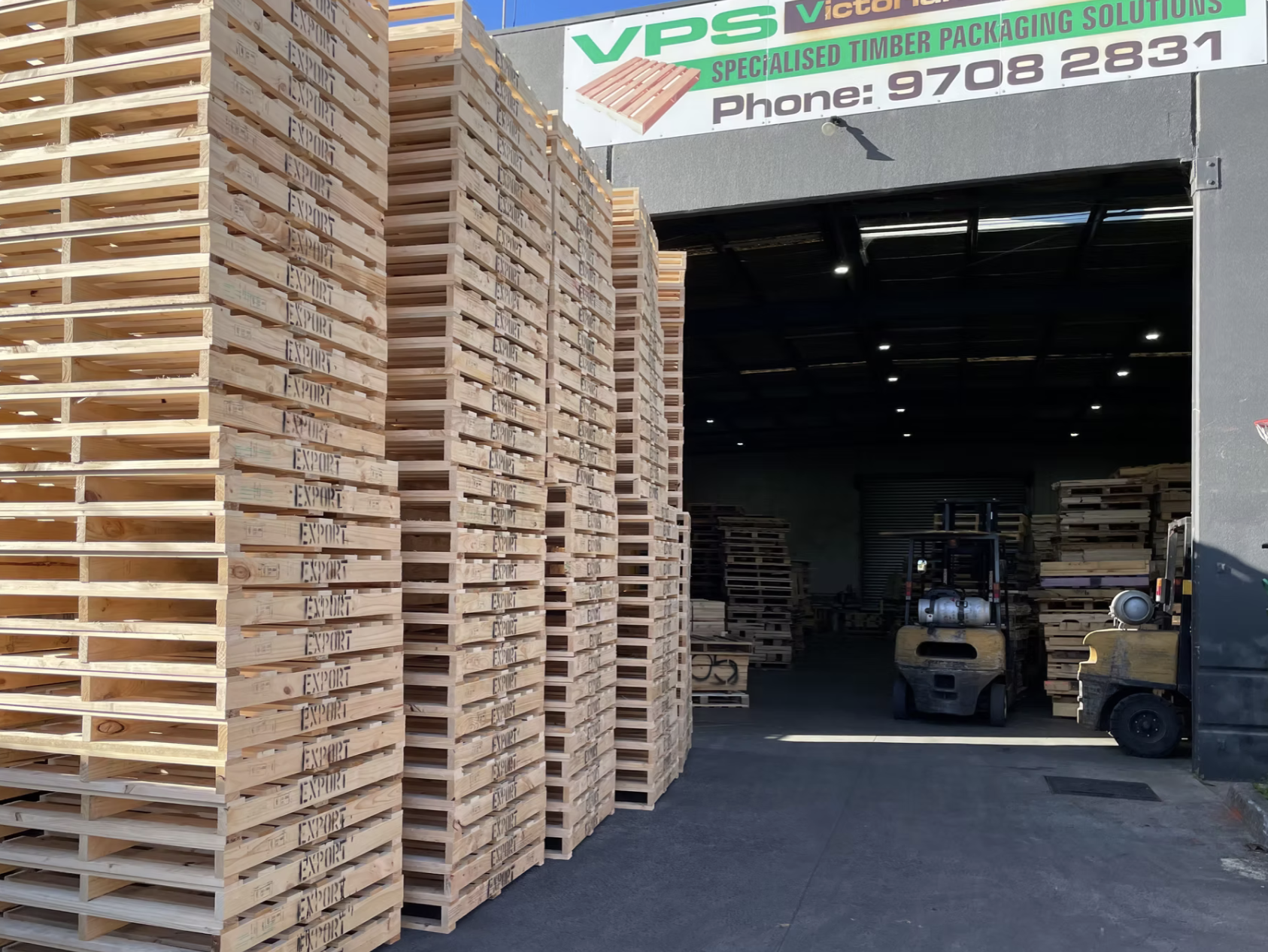 Wooden pallets and warehouse with forklifts